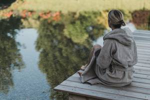 Woman at the bathing pond in the Gart'l Spa at the Naturhotel Molzbachhof.