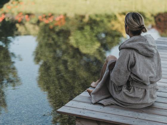 Woman at the bathing pond in the Gart'l Spa at the Naturhotel Molzbachhof.