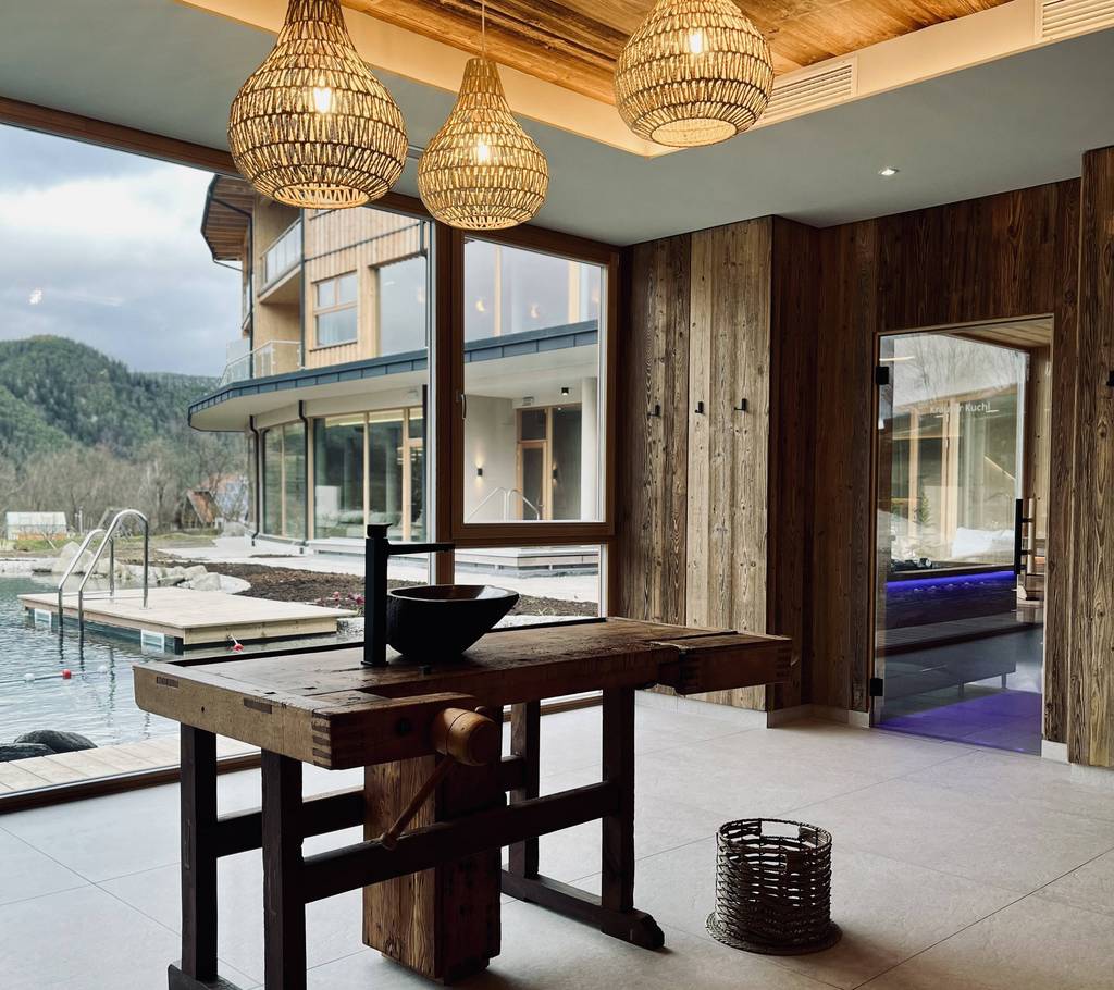 Washbasin with a view of the pool in the wellness area of the Naturhotel Molzbachhof.