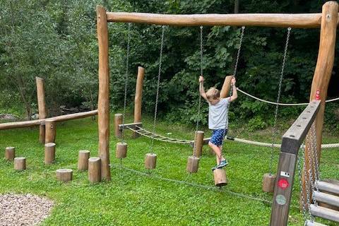 Child at a playground during a family vacation at the Naturhotel Molzbachhof.