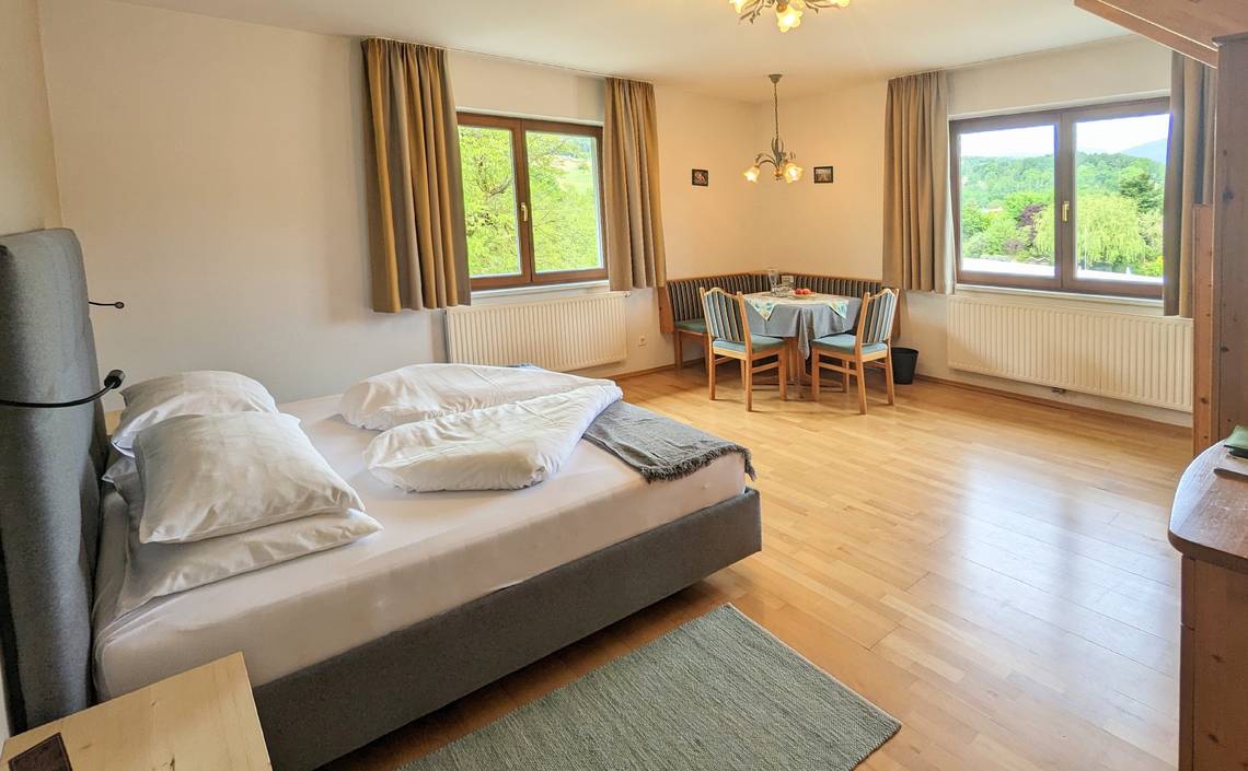 Tower room with double bed and sitting area in the Naturhotel Molzbachhof.