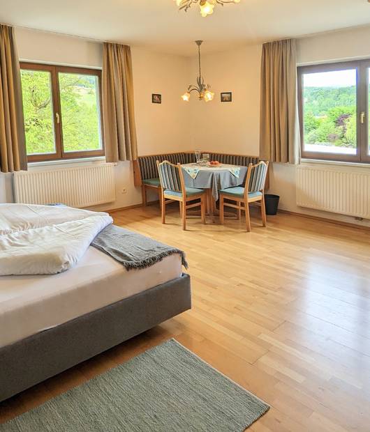 Tower room with double bed and sitting area in the Naturhotel Molzbachhof.