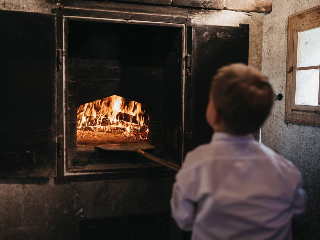 Child in front of the bread oven in the mill at the Naturhotel Molzbachhof.