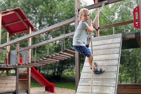 Child at a playground during a family vacation at the Naturhotel Molzbachhof.